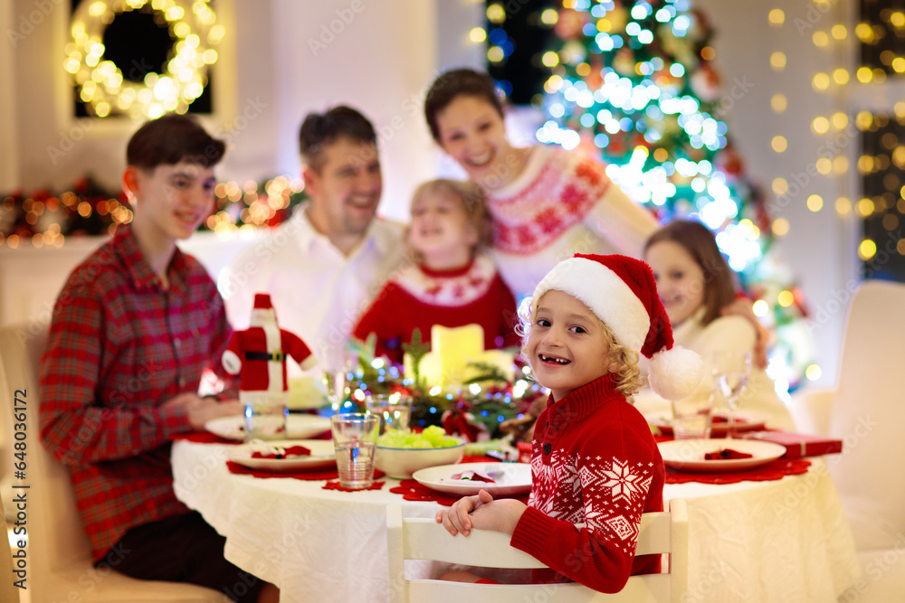 Family with kids having Christmas dinner at tree Family with kids having Christmas dinner at tree