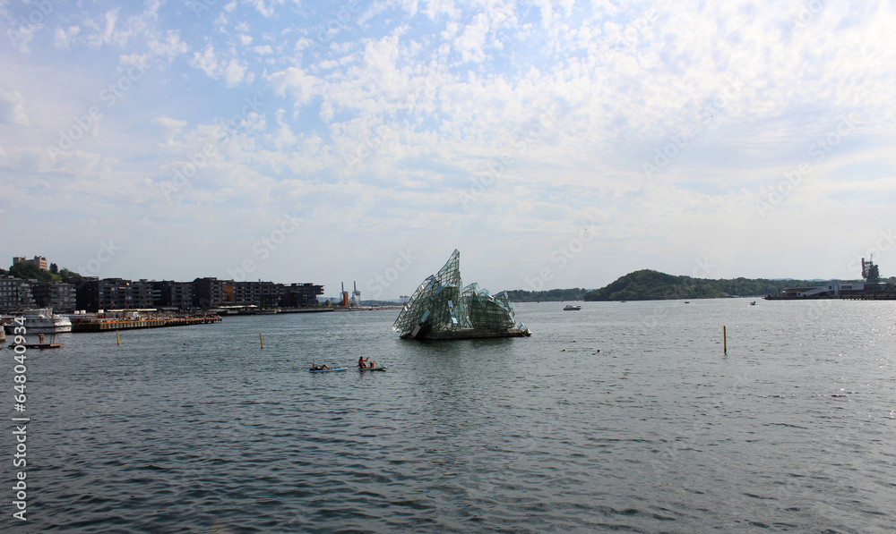 Fototapeta premium City Oslo harbor with monument in the sea in the sunny morning over beautiful big city background, luxury summer adventure, active vacation in Oslofjord, Norwey