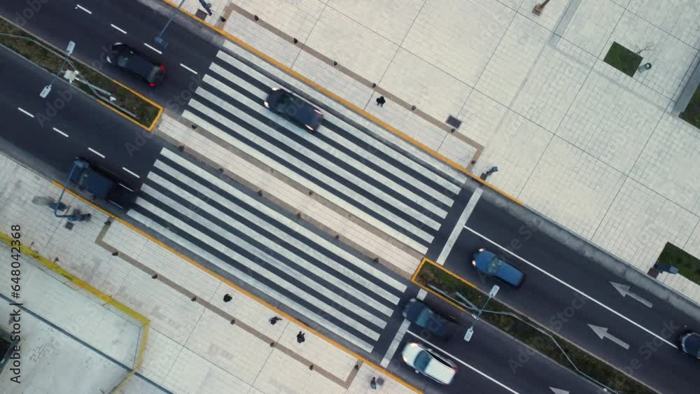 Cars pass a pedestrian crossing, pedestrians walk on the sidewalk, top view Cars pass a pedestrian crossing, pedestrians walk on the sidewalk, top view