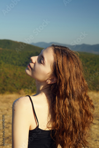 portrait of a happy woman in the mountains, with her hair blown by the wind on a sunny day