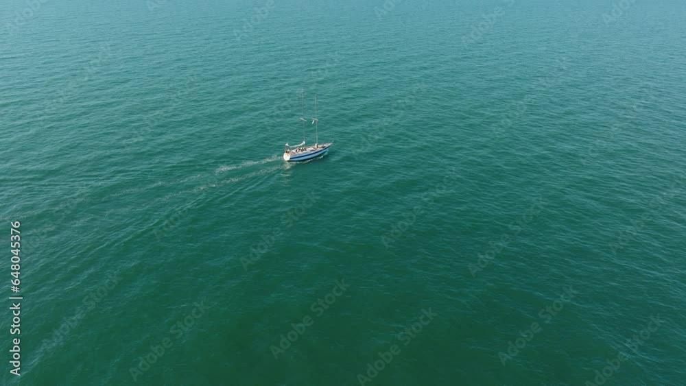 Aerial establishing view of a white sailboat in the calm Batltic sea, white sailing yacht in the middle of the boundless sea, sunny summer day, wide done shot moving backward Aerial establishing view of a white sailboat in the calm Batltic sea, white sailing yacht in the middle of the boundless sea, sunny summer day, wide done shot moving backward