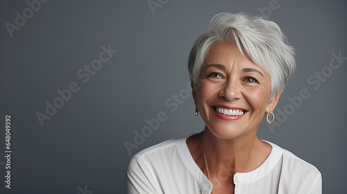 portrait of woman, closeup of a joyful senior woman with elegant grey hair, radiantly smiling to showcase her impeccable teeth for a dental advertisement