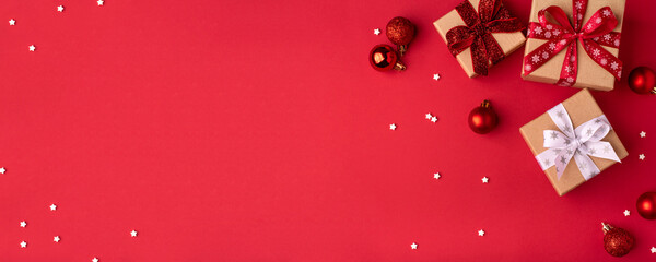 Christmas gift boxes with red balls on red background.