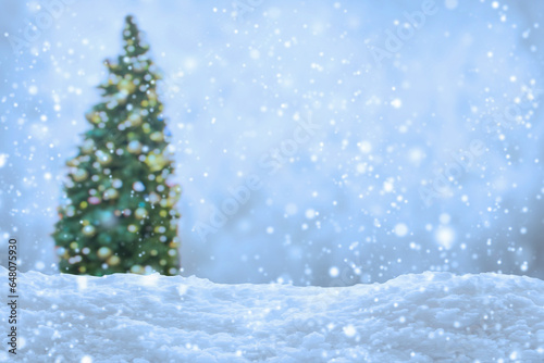 Empty white snow with blur Christmas tree with bokeh light background © Piman Khrutmuang