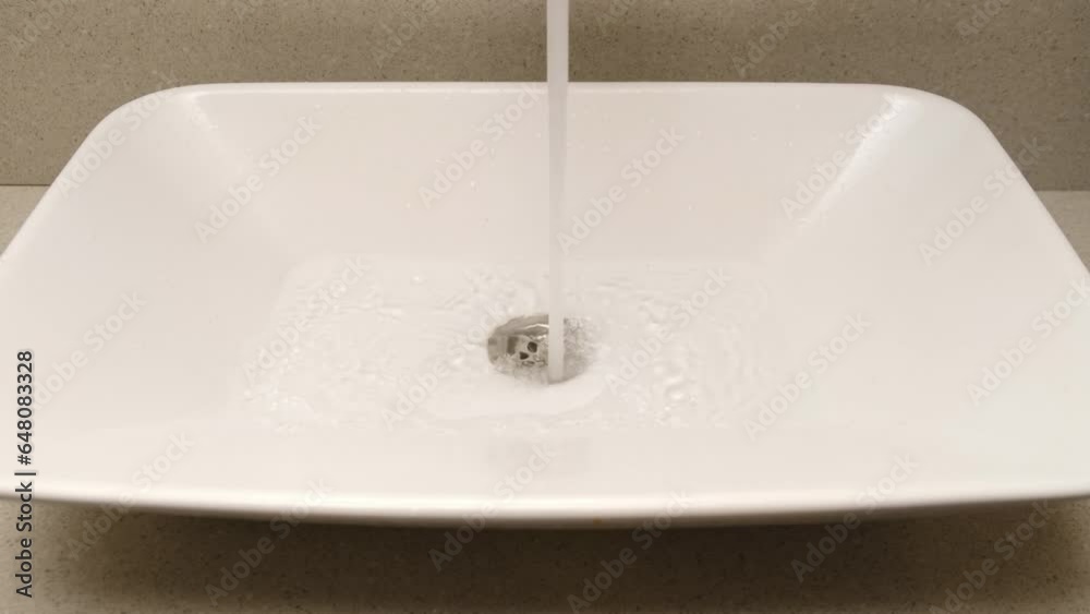 White bathroom sink on an black wooden countertop with a soap dispenser White bathroom sink on an black wooden countertop with a soap dispenser