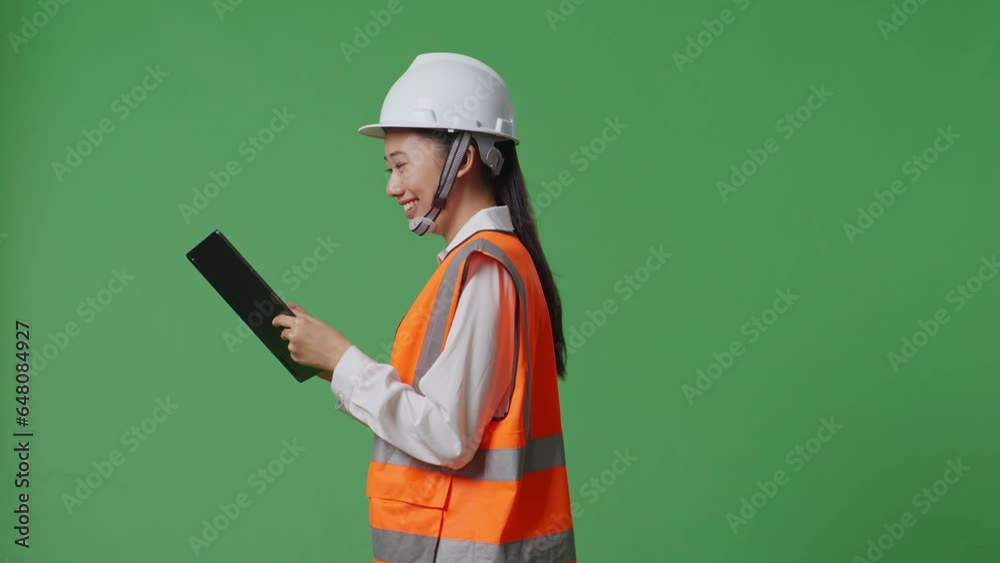 Side View Of Asian Female Engineer With Safety Helmet Using Tablet While Walking In The Green Screen Background Studio
Side View Of Asian Female Engineer With Safety Helmet Using Tablet While Walking In The Green Screen Background Studio