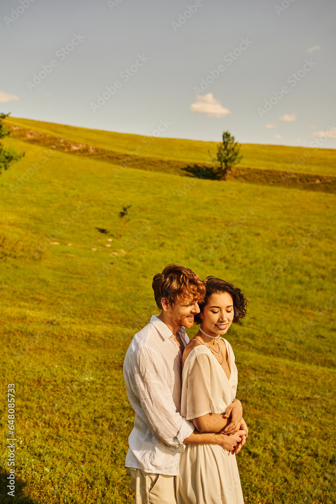 just married couple, happy man hugging asian bride in green field, scenic and tranquil landscape just married couple, happy man hugging asian bride in green field, scenic and tranquil landscape