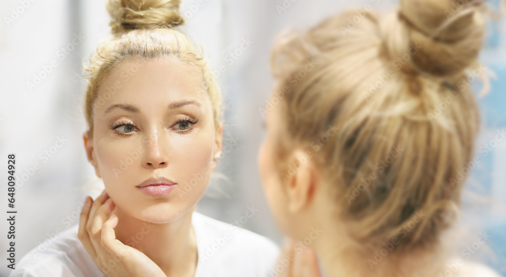 woman looking in the mirror in the bathroom and taking care of her skin. woman looking in the mirror in the bathroom and taking care of her skin.