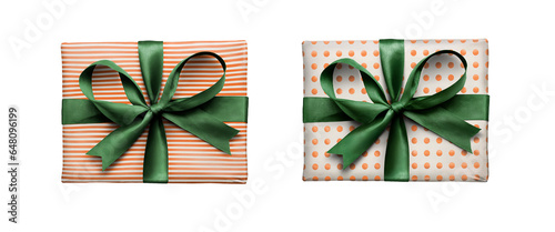 Top view of Christmas, birthday or valentine presents decorated in orange spots and stripes with a green ribbon bow isolated against a transparent background. photo