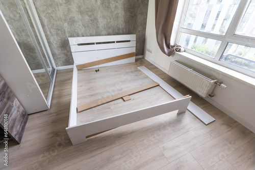 Φωτογραφία The furniture assembler assembles the bed frame, do it yourself and assemble new