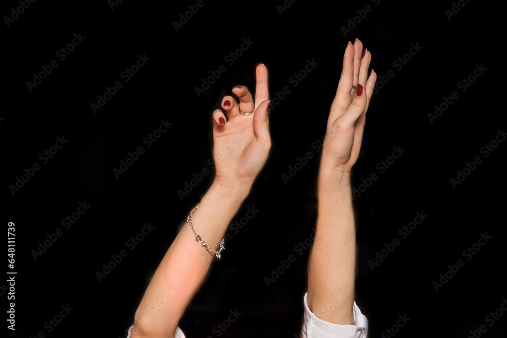 Fototapeta premium Women's hands up gesture of a girl's hand while dancing on a black background