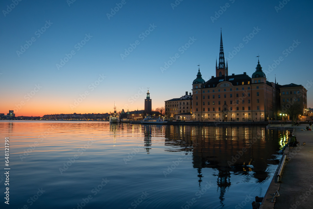 Dusk over the lake in central Stockholm, with the skyline visible, the town hall and parts of Riddarholmen's old buildings. Copy space