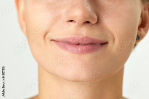 Cropped image of female face, nose, lips and chin isolated on white background. Plastic surgery, filler, lip augmentation. Concept of natural beauty, cosmetology and cosmetics, skin care, spa. Ad