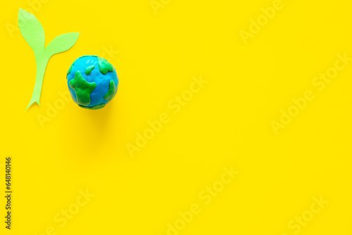 Clay globe planet Earth with paper green plant. Safe our planet concept