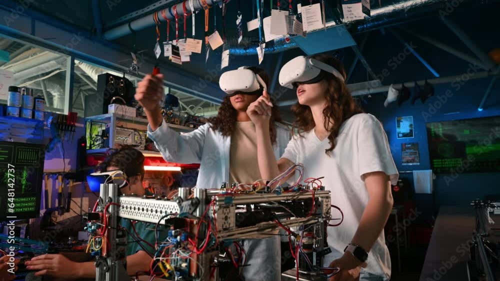 Group of young people in VR glasses doing experiments in robotics in a laboratory. Robots on the table