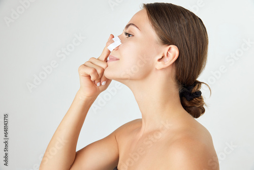 Beautiful young woman with well-kept skin  having plaster on nose after rhinoplasty isolated on white background. Concept of beauty  plastic surgery  cosmetology  skin care  spa. Ad