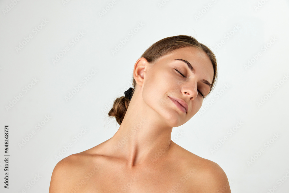 Portrait of tender young woman with bare shoulders isolated on white background. Soft, well-kept skin. Concept of natural beauty, cosmetology and cosmetics, skin care, spa. Ad Portrait of tender young woman with bare shoulders isolated on white background. Soft, well-kept skin. Concept of natural beauty, cosmetology and cosmetics, skin care, spa. Ad