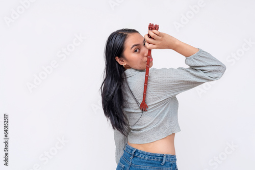 A young asian woman using a backscratcher. Using a convenient toll to scratch her back. Isolated on a white background. photo