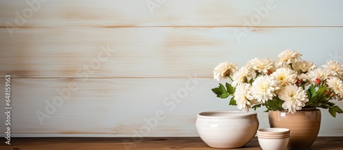 white dishes a vase with a flower bowls for soup and a boat for gravy on a wooden surface