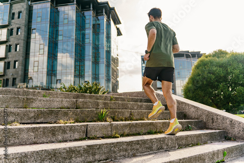 Young man fitness exercises. Motivation and mental health playing sports. Interval endurance training. A running instructor in sneakers doing a workout alone.