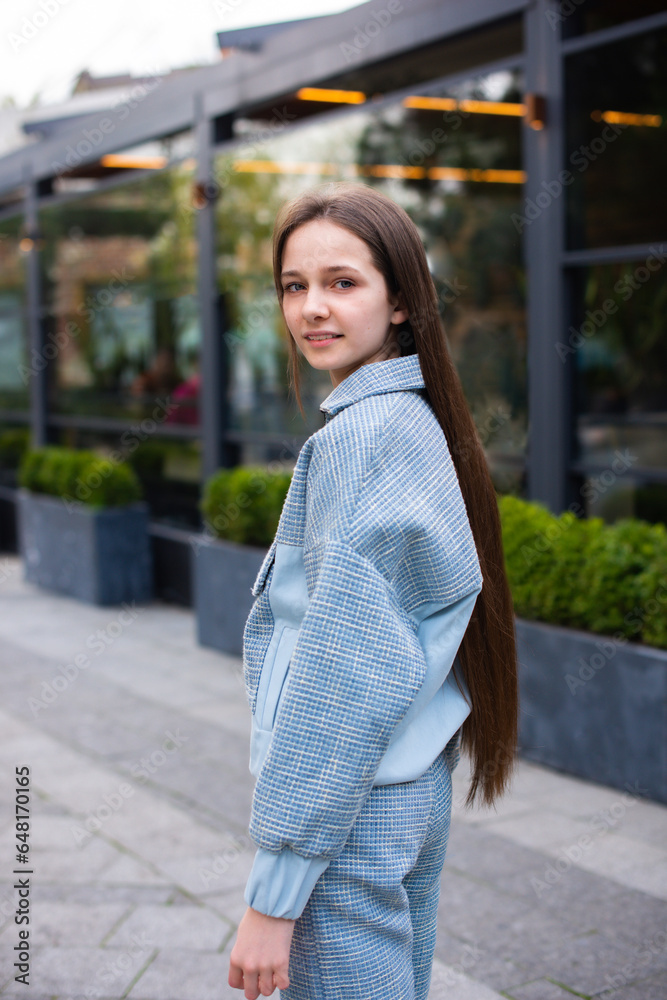 teenage girl with long hair walking in city street. meeting with friends outdoors