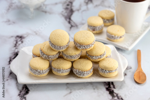Bilde på lerret Homemade cornstarch alfajores filled with dulce de leche with coconut and cup of