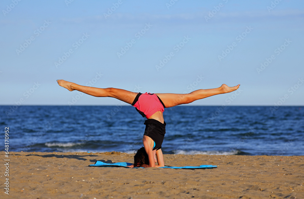 girl performed gymnastic exercises in the summer with her head below and her legs above girl performed gymnastic exercises in the summer with her head below and her legs above