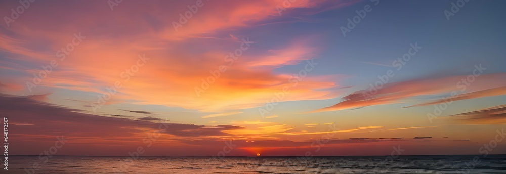 海のホライゾンに広がる夕暮れのパノラマ：深い青色の海と鮮やかな空、夕日の光が雲をピンクとオレンジに染め上げる