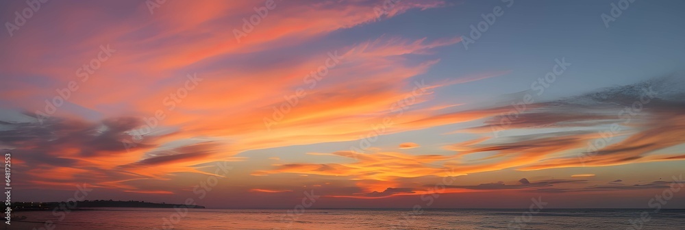 海のホライゾンに広がる夕暮れのパノラマ：深い青色の海と鮮やかな空、夕日の光が雲をピンクとオレンジに染め上げる