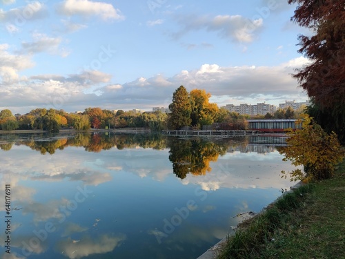Autumn trees reflected in water. Fall season on the lake shore © dianacoman