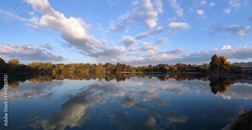 Autumn trees reflected in water. Fall season on the lake shore