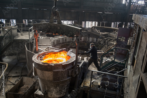 Steelworker at work near the tanks with hot metal