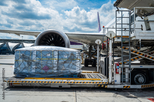 Air cargo logistic containers are loading to an airplane.
