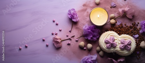 Top down view of dalgona coffee adorned with foam hearts chocolate chips cookies candles and purple lilac flowers on a light table