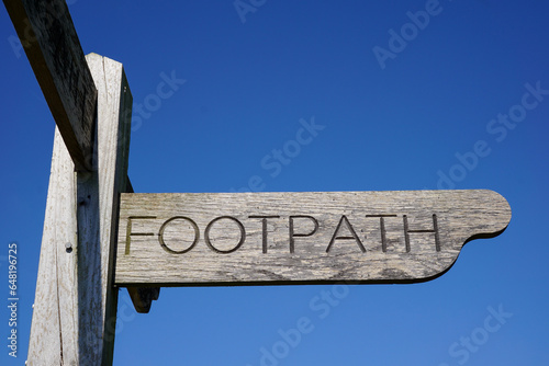 wooden footpath sign in the countryside. fingerpost directional marker sign for public trail photo