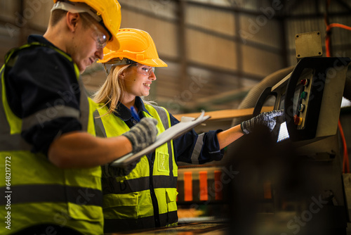 actory engineer workers standing to control panel switch. people works at heavy machine at industry factory. with machinery equipment plant technology. smart industry worker operating. photo