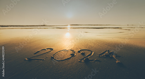 Happy New Year 2024 ocean sunrise on the beach shore concept