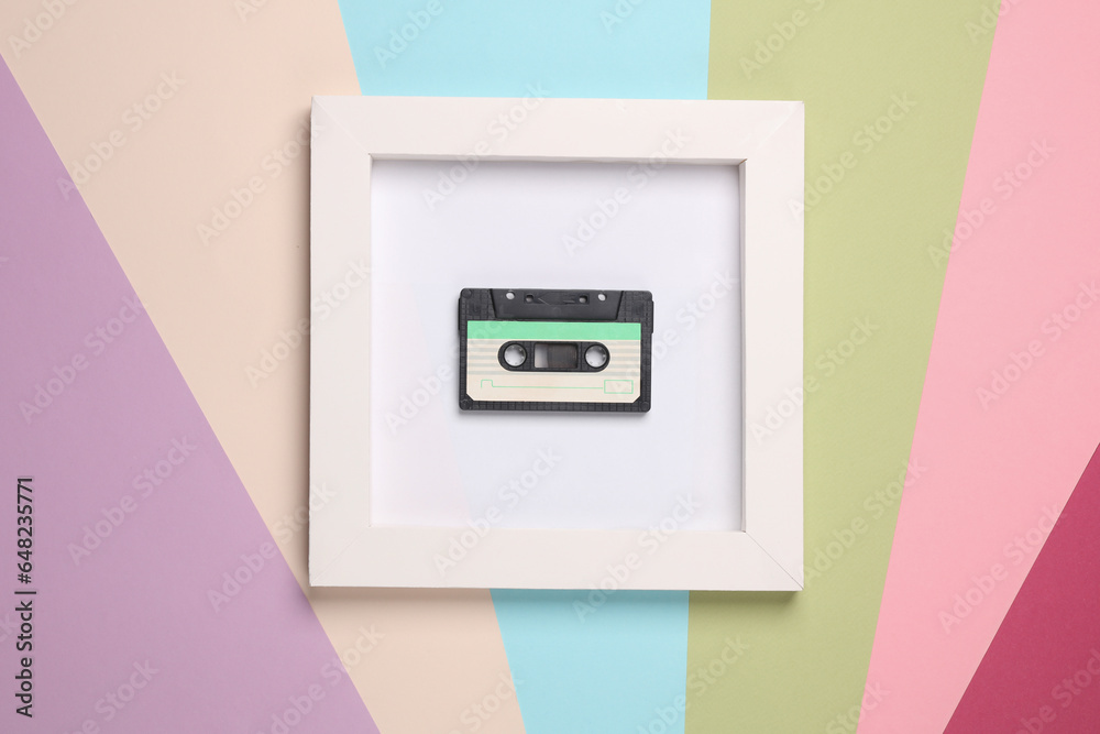 Retro 80s audio cassette in white square frame on colored background. Aesthetic minimal still life. Conceptual photo. Modern art. Top view Retro 80s audio cassette in white square frame on colored background. Aesthetic minimal still life. Conceptual photo. Modern art. Top view