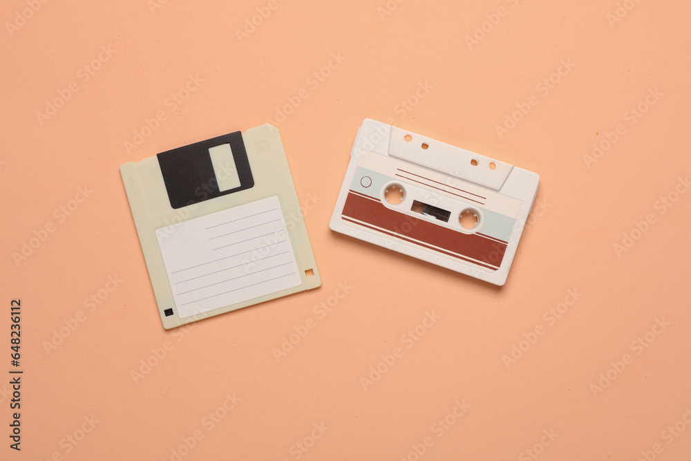 Floppy disk and audio cassette on a pink background. Retro 80s. Top view