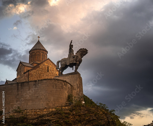 The evening  view on the illuminated statute of the King  Vaghtang and Metheki St Virgin church. photo