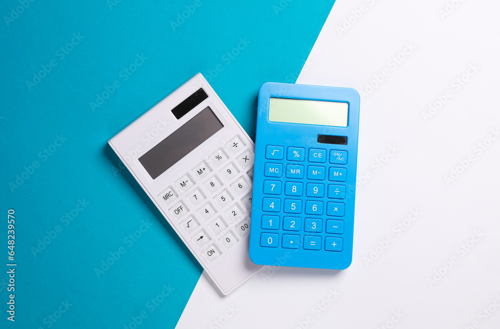 Two calculators on a blue white background. Top view Two calculators on a blue white background. Top view