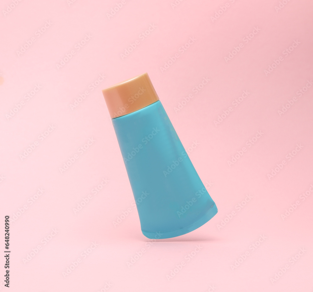 Blue cream tube levitating in anti-gravity on a pink background. Mockup, template for design Blue cream tube levitating in anti-gravity on a pink background. Mockup, template for design
