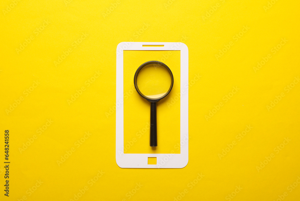 Paper-cut smartphone icon with magnifying glass on a yellow background. Searching for information on the Internet - obrazy, fototapety, plakaty 