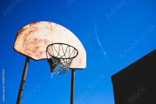 Rusty basketball hoop against a blue sky; Beloeil quebec canada