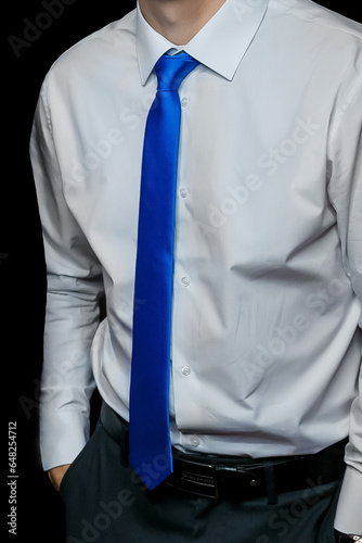 Men's clothing style fashion business man look white shirt and blue tie close-up on black background, soft focus