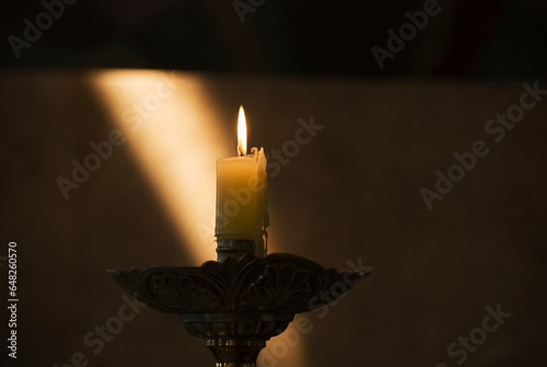 Candle Burning With Sun Ray On The Wall In The Background; Mendoza, Argentina