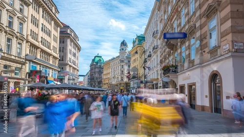People walking shopping in Graben St. timelapse hyperlapse, old town main street of Vienna with many shops and restaurants, Austria. The column, called The Pestsaule in front,Vienna main street.