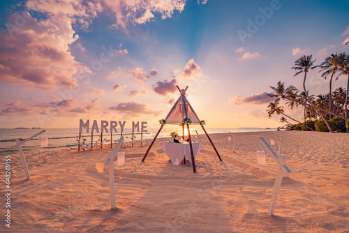Fotografia Romantic Marry Me sign at sunset beach, destination island scene sea sand sky background