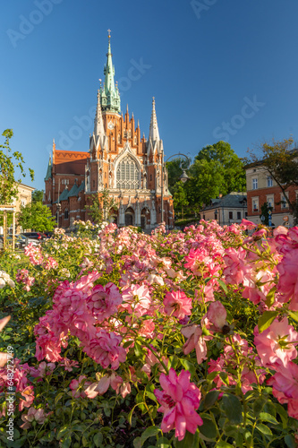 Krakow, Poland, st Joseph church in Podgorze district over blooming roses.