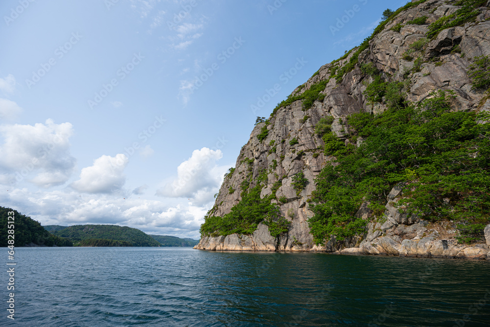 Steep cliffs off a mountain into a deep fjord.